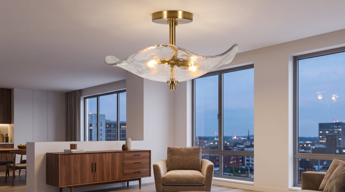 A stylish semi-flush ceiling light with a wavy, textured glass shade and brass finish illuminates a modern living room. It adds a sophisticated glow to the elegant space.