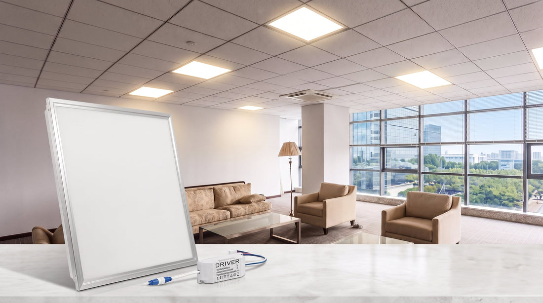 A 2x2ft LED panel light and its driver are displayed on a white marble table, set against a modern office interior. The driver is labeled DRIVER 200-240Vac 50/60Hz 0.2A 50W IP20 CE ROHS IEC.