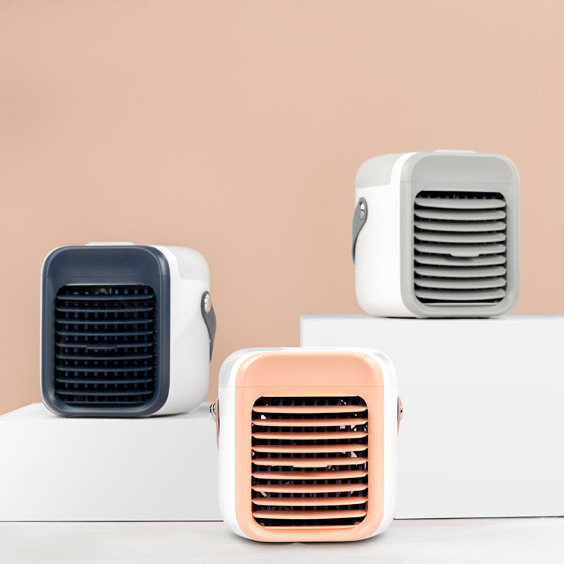 Three Zainzio portable cooling fans in blue, pink, and white are displayed. These compact, cube-shaped misting coolers feature front grilles and side handles.