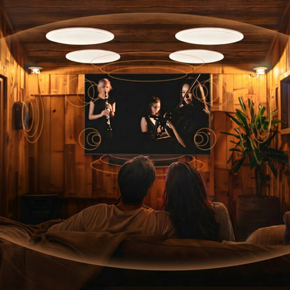 A couple watches a concert on TV in a warm, wood-paneled room. Sound waves illustrate immersive audio from four in-ceiling speakers and surrounding soundbars.