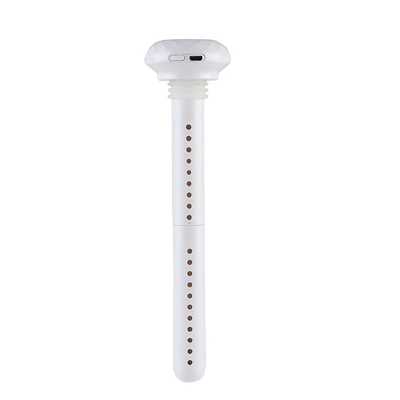 A white USB stick humidifier stands vertically, featuring a faceted top with a visible USB port. The long, slender body has two sections, both perforated with small holes.
