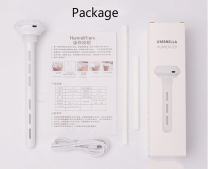 The humidifier's package contents are shown: the white stick humidifier, USB cable, filter sticks, instruction manual titled "Humidifiers" and "操作说明", and its box labeled "UMBRELLA HUMIDIFIER".