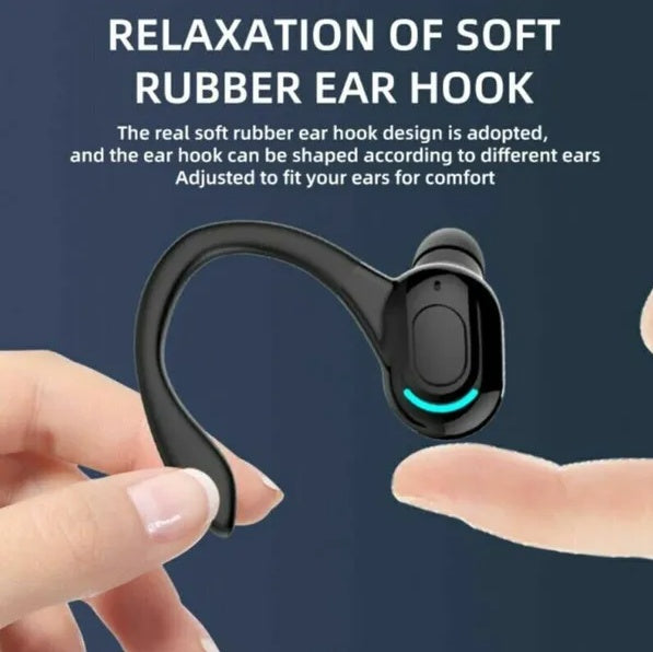 Black wireless earbud with soft rubber ear hook being held by a hand against a dark blue background.