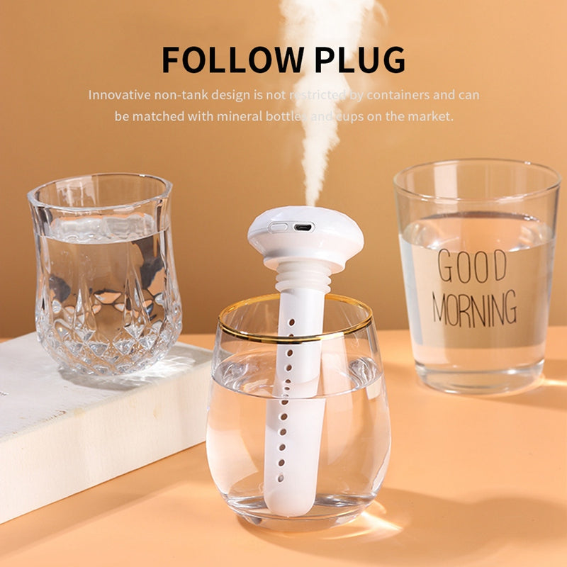 A white stick humidifier plugs into a glass of water, emitting mist, flanked by two other glasses. FOLLOW PLUG. Its non-tank design works with various containers.