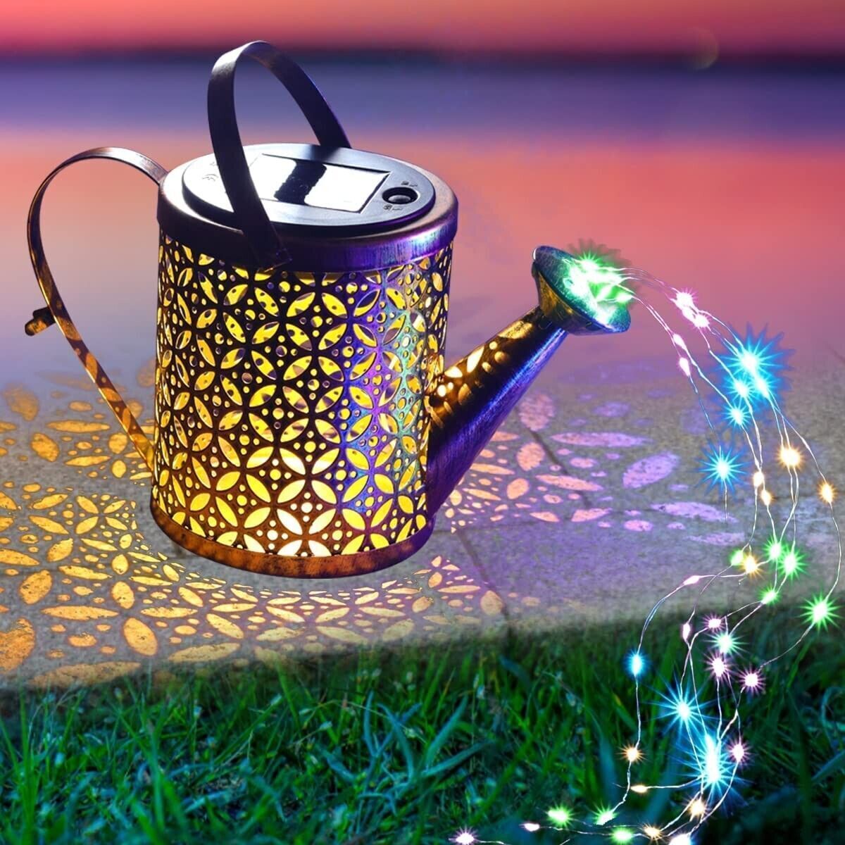 Decorative solar light shaped like a watering can with colorful string lights on grass.