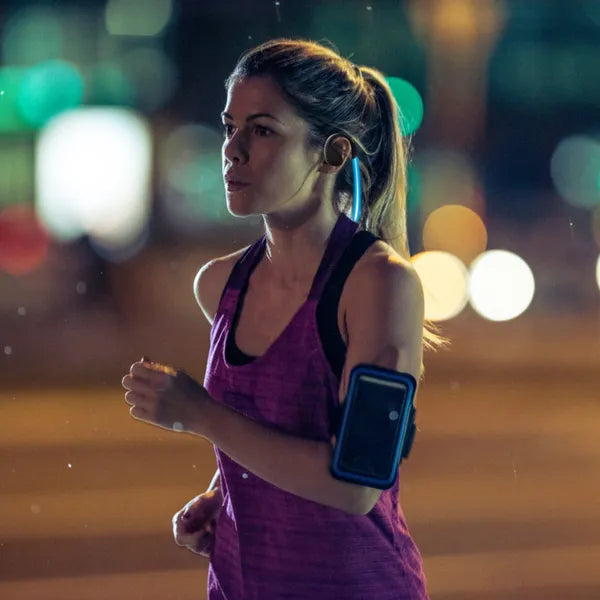 Woman running at night with city lights in the background