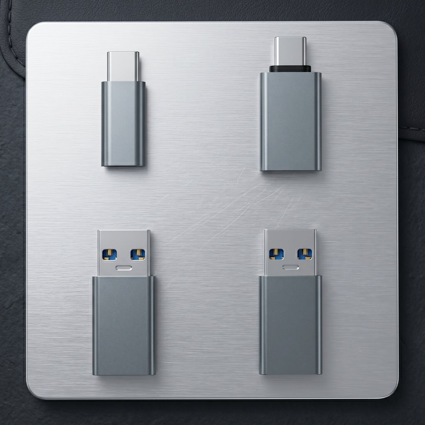 Four gray USB data shielding adapters are displayed on a metallic surface. They include two USB-C to USB-C and two USB-A to USB-C types.