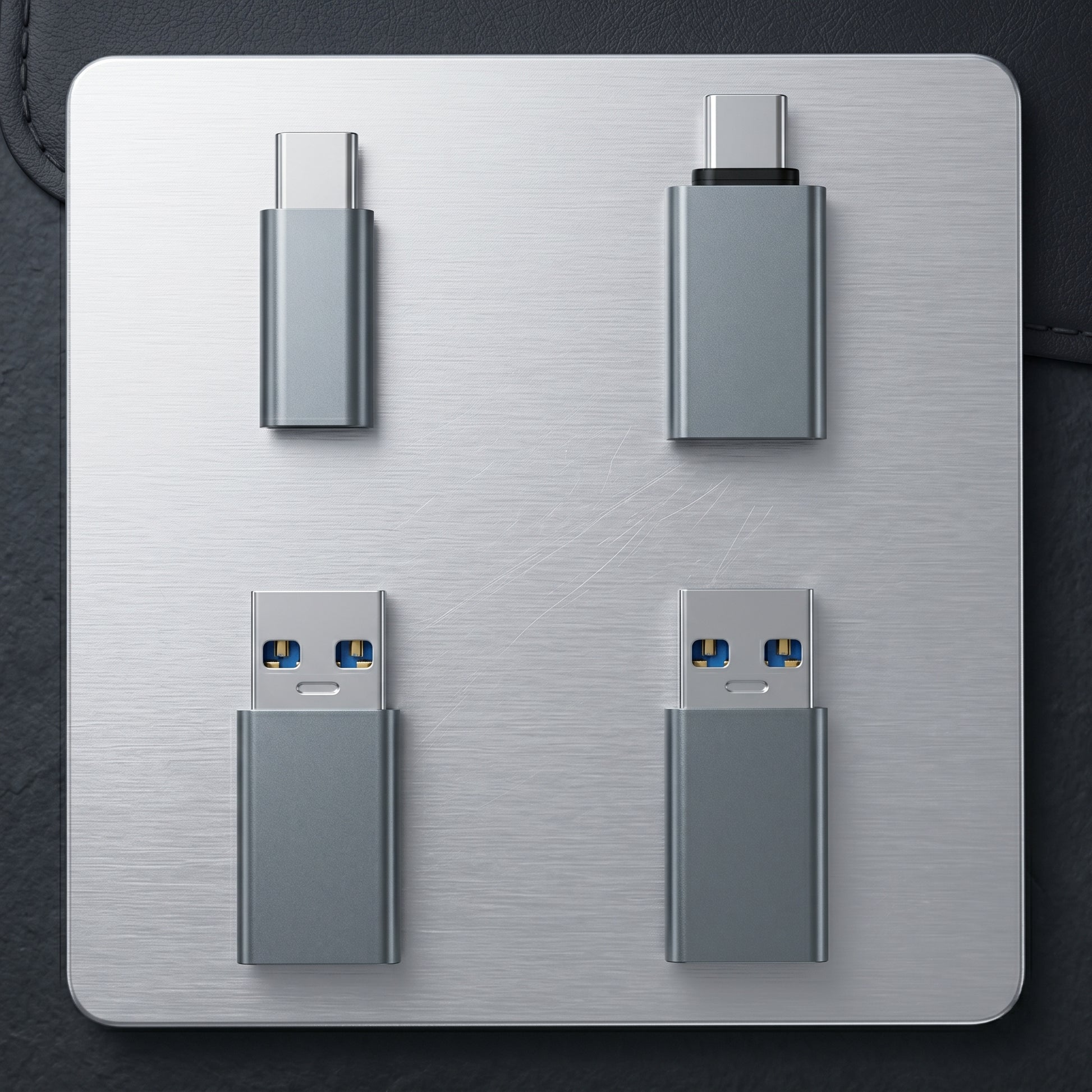 Four gray USB data shielding adapters are displayed on a metallic surface. They include two USB-C to USB-C and two USB-A to USB-C types.