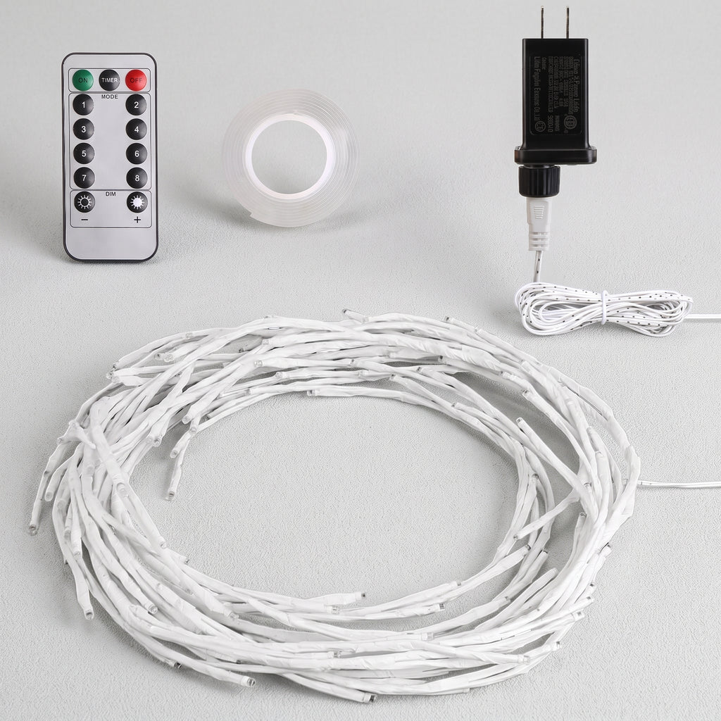 White LED string lights coiled in a large circle, shown with a silver remote control, a roll of clear adhesive tape, and a black power adapter on a light gray background.