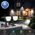 Two black solar-powered outdoor light fixtures displayed in front of a house at night, with one fixture mounted on a stone ledge and the other shown in use on a garden path. The image includes a ZAINZIO brand logo in the top left and feature icons at the bottom indicating 1200 lumens, IP65 waterproof, 25h runtime, and 3 brightness modes.