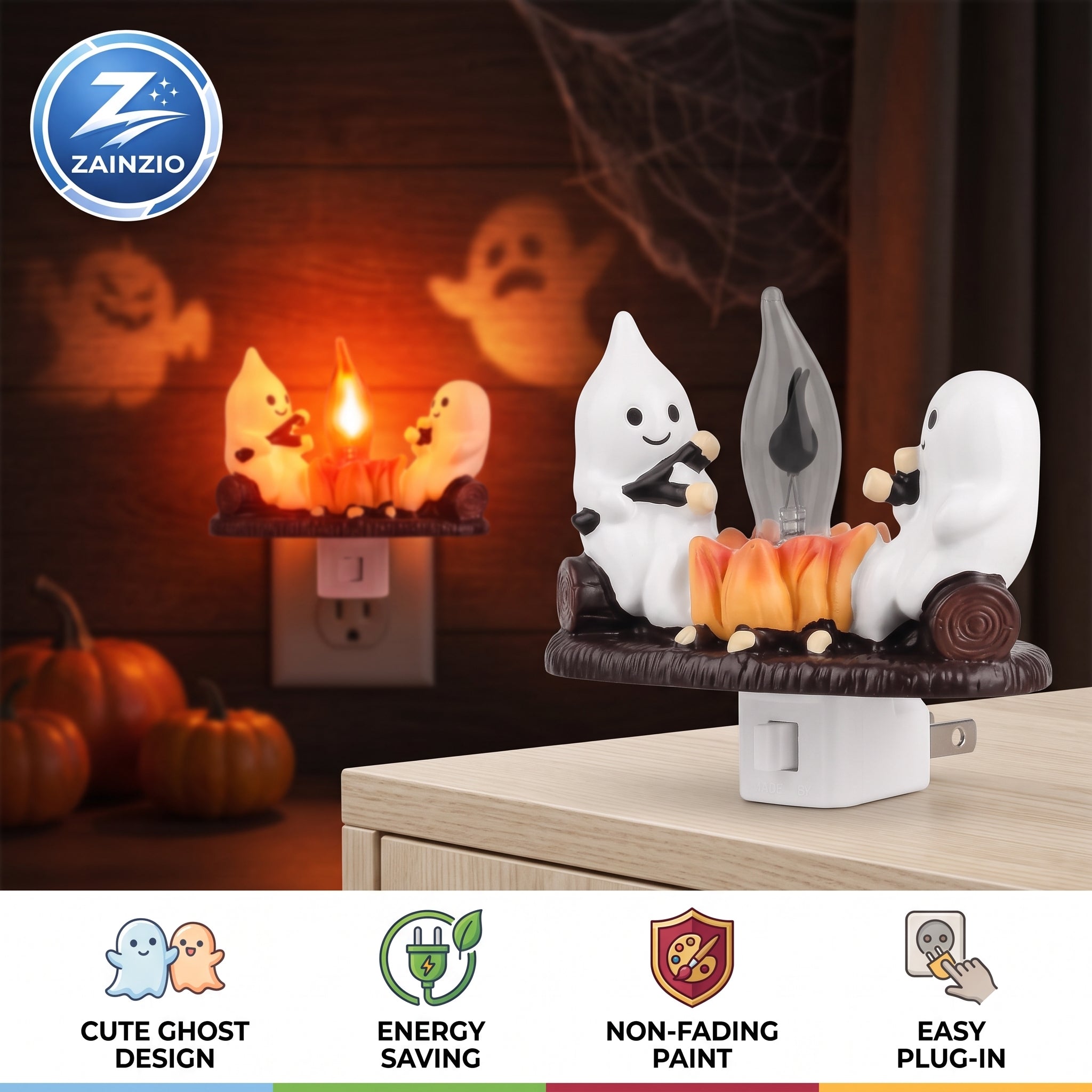 A Zainzio Halloween night light plug-in featuring two white cartoon ghosts sitting on a log and playing with a small flame. The main product is shown in the foreground on a tabletop, with a smaller inset view of the same product plugged into an outlet in the background.