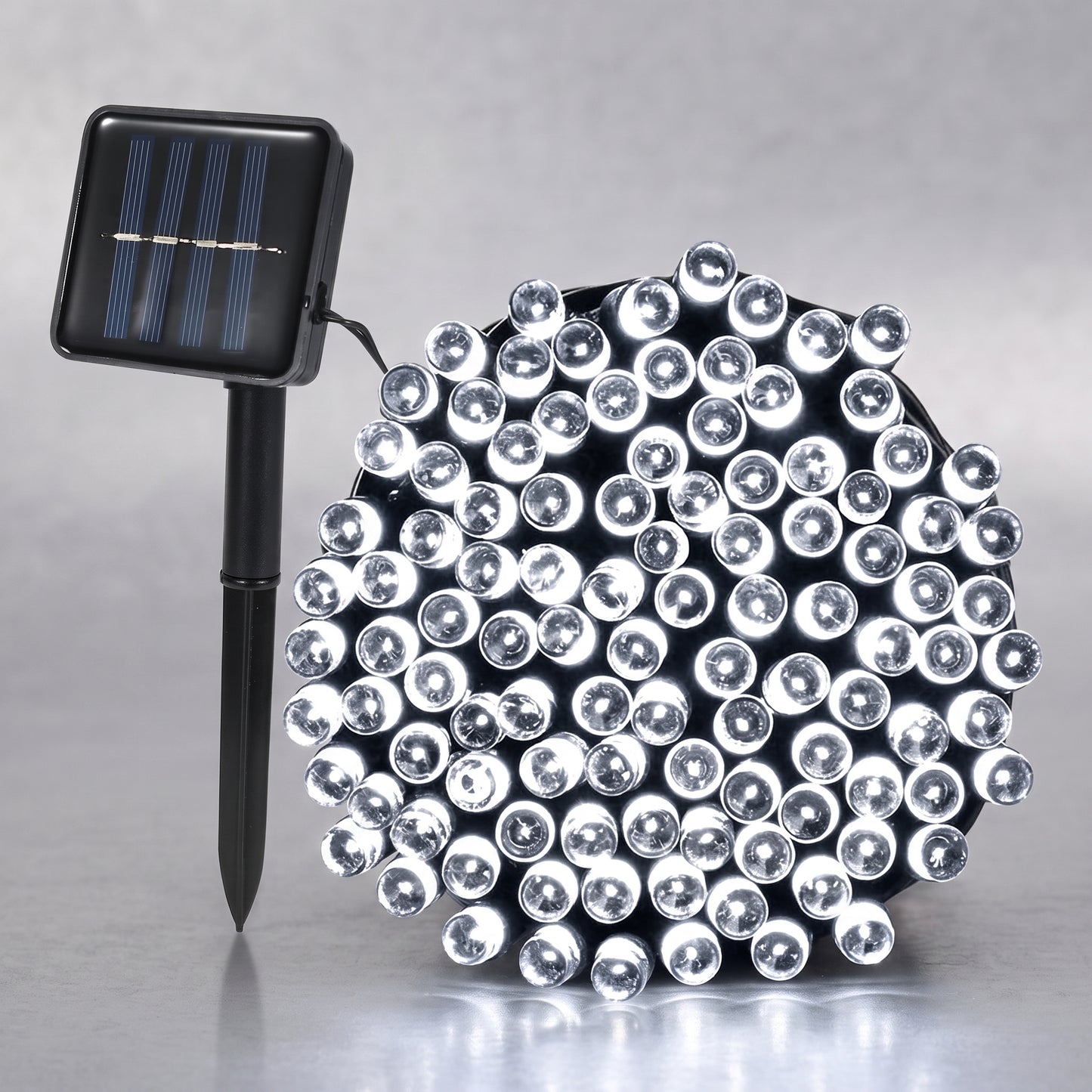 A solar-powered LED light string with a black stake-mounted solar panel on the left and a dense cluster of clear dome-shaped LED bulbs on the right, set against a neutral gray background.