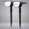 Two black solar-powered stake-mounted LED garden lights shown side by side against a neutral gray background.