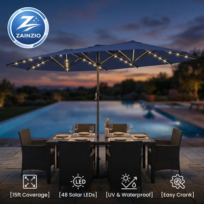 Zainzio patio umbrella with LED lights over a dining table by a pool at dusk.