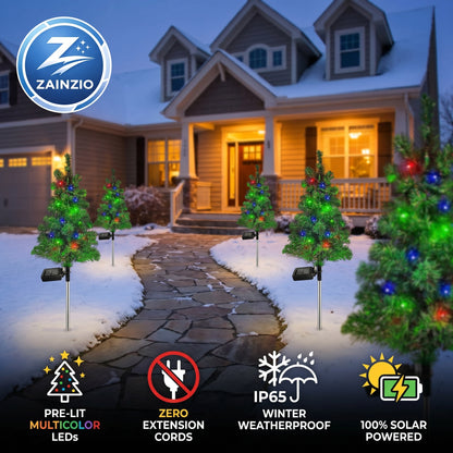 Zainzio outdoor Christmas trees with lights in front of a house at night.