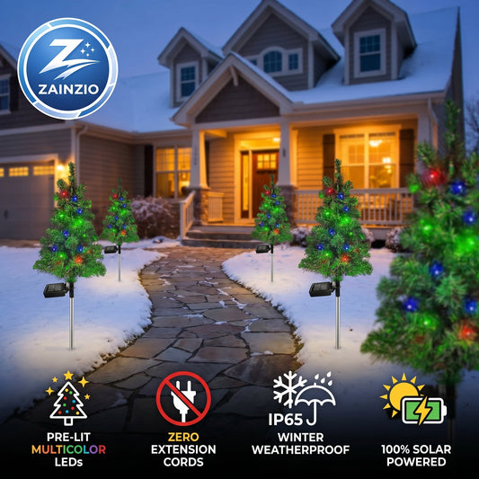 Zainzio outdoor Christmas trees with lights in front of a house at night.