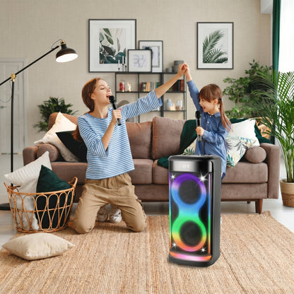 A woman and child happily sing into microphones with a colorful RGB party speaker. The speaker displays "08:58" and features vibrant "8"-shaped lights.