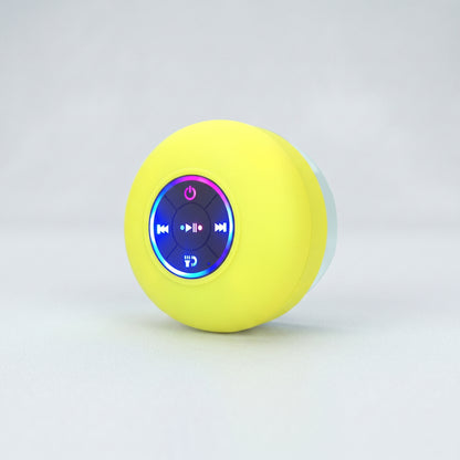 A bright yellow Zainzio BTS07 waterproof Bluetooth speaker is shown. Its front features illuminated blue and purple control buttons for power, media playback, and calls.