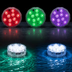 Four round underwater LED light fixtures shown in red, green, purple, and white, with the bottom pair illuminated in water creating colored ripples on a dark background.