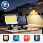 Two Zainzio solar motion-activated outdoor floodlights displayed on a porch at dusk, with one light turned on casting a warm yellow beam toward the house. The image includes feature icons at the bottom and a Zainzio logo in the top left.