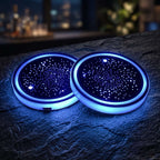 Two Zainzio Starry Sky LED car cup holder coasters glowing with blue ambient light on a dark tabletop.