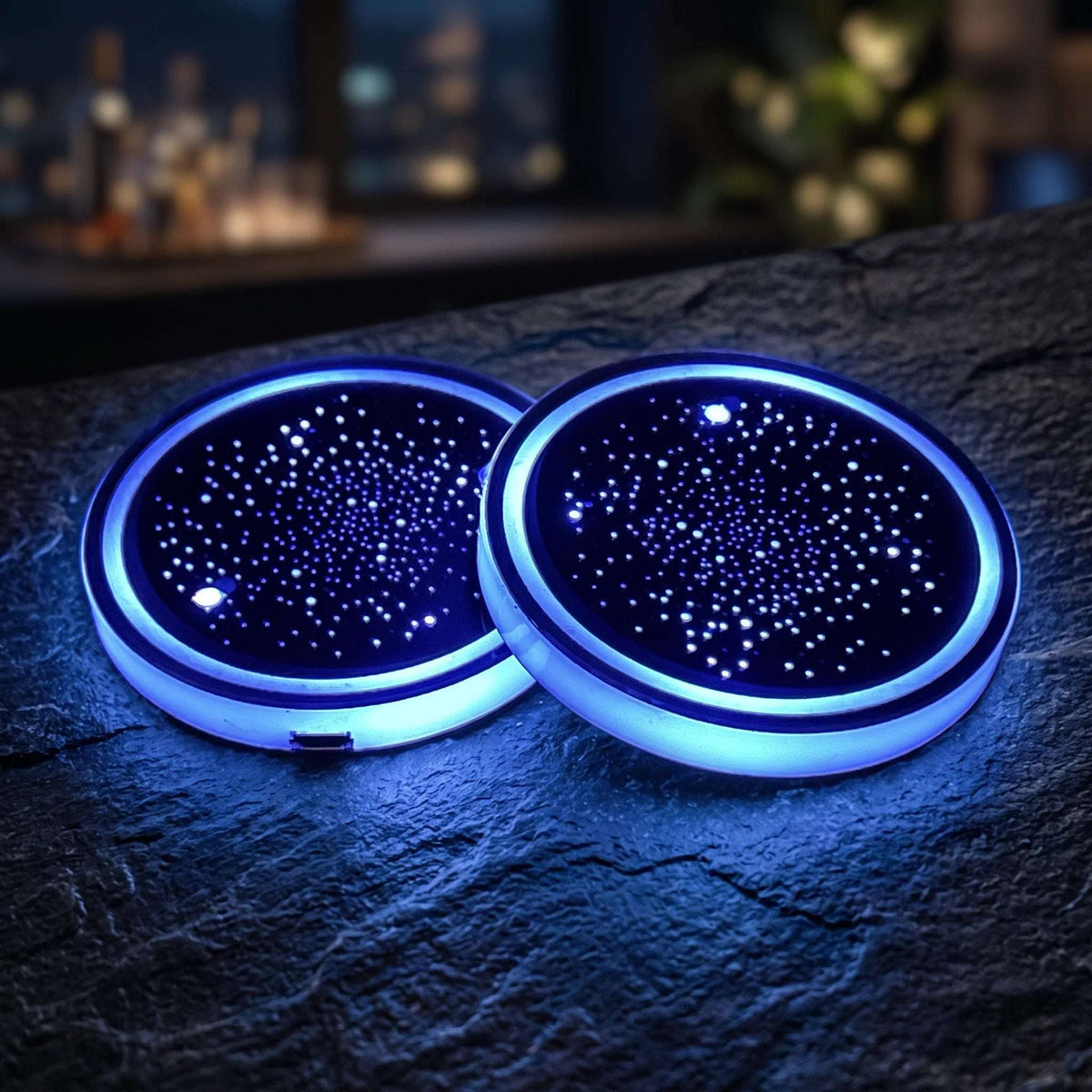 Two Zainzio Starry Sky LED car cup holder coasters glowing with blue ambient light on a dark tabletop.