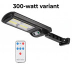 A black 300-watt solar LED light with a wall mount bracket and a separate white remote control, shown on a plain white background with the text '300-watt variant' above.