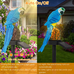 Solar-powered parrot garden light shown in daylight and nighttime side-by-side comparisons. The product features a bright blue parrot perched on a black stake with a small solar panel extending from the side, mounted on a garden post.