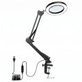 Black adjustable clamp-on USB magnifying lamp with a circular lens, shown with its USB cable and power switch on a white background.