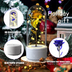 Decorative flower under a glass dome with Bluetooth speaker, surrounded by festive elements.