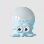 A light blue octopus-shaped speaker with a glossy translucent dome on top, three circular buttons, and large cartoon eyes on the front, shown against a plain light gray background.