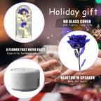 A promotional collage for a holiday gift set featuring a preserved blue rose under a glass dome with warm LED lights, a small round Bluetooth speaker, and a hand holding a wrapped gift box in a festive blurred background. Text highlights HD glass cover, LED lights, Bluetooth speaker, and fade-resistant flower.