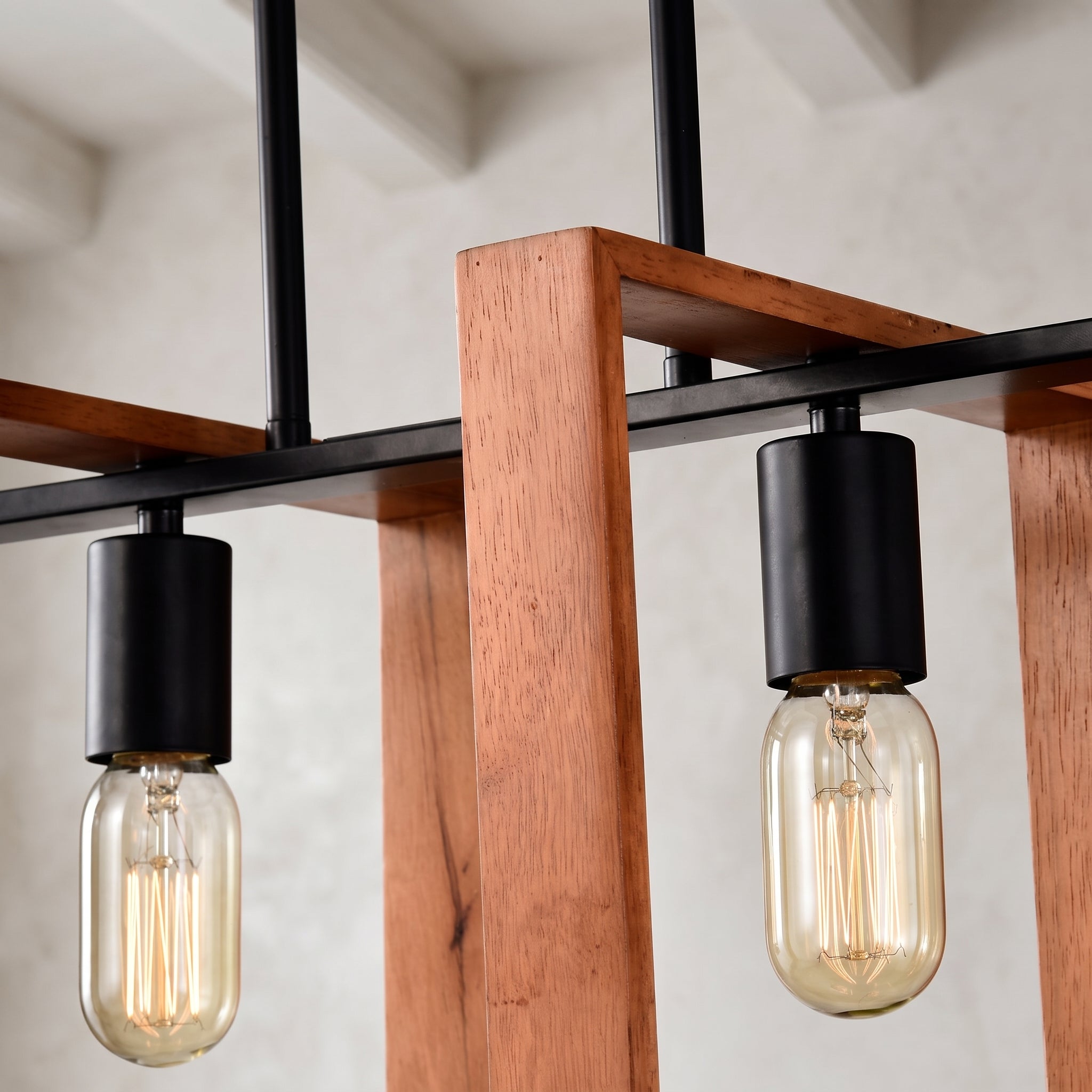 Industrial-style pendant light fixture with black metal hardware, a warm brown wooden frame, and clear glass bulbs showing a glowing filament.