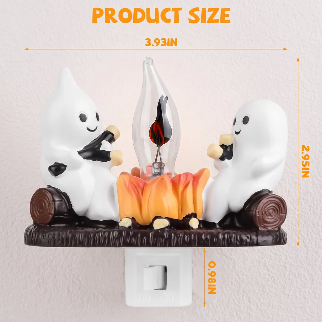 A Halloween night light product with two white cartoon ghosts roasting over a small orange campfire on a dark brown base, shown with overlaid dimension lines and text indicating product size.