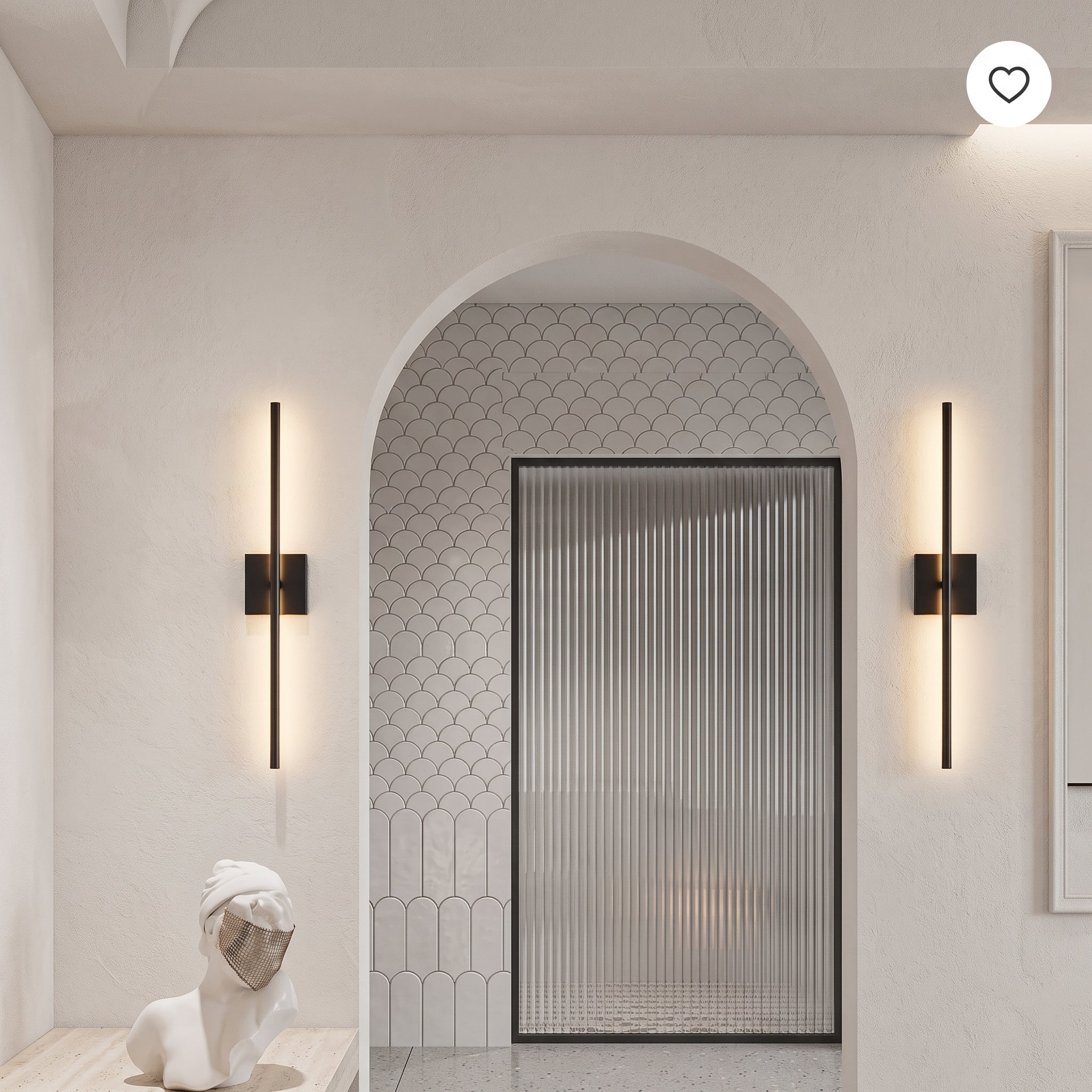 A modern bathroom interior with two slim black wall sconces mounted on cream walls on either side of an arched doorway. The sconces have vertical light bars that glow warm white.