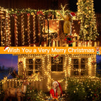 A festive Christmas house decorated with warm yellow string lights, wreaths, ornaments, and a tree, with children and a reindeer figurine in front. A large orange banner across the center reads 'Wish You a Very Merry Christmas'.