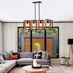 A modern multi-light linear chandelier with warm wood-look rectangular shades and black metal framing, hanging in a contemporary living room above a gray sectional sofa.