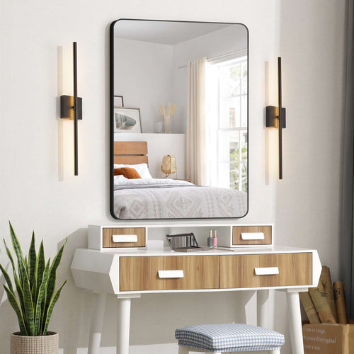 Modern bedroom with a large rectangular wall mirror above a white vanity and wood-grain drawers.