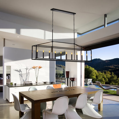 A modern rectangular black metal chandelier with candle-style bulbs hanging over a dining table in a contemporary open-concept home with a kitchen and outdoor mountain view.