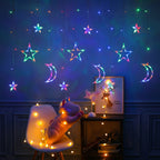 Multicolor LED star and moon curtain string lights hanging on a dark blue wall in a decorated children's room, with a plush toy on a chair and warm fairy lights around it.