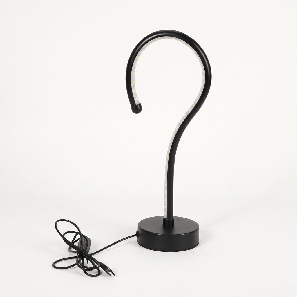 A modern black metal table lamp with a curved hook-shaped arm and a round base, shown with its power cord on a clean white background.