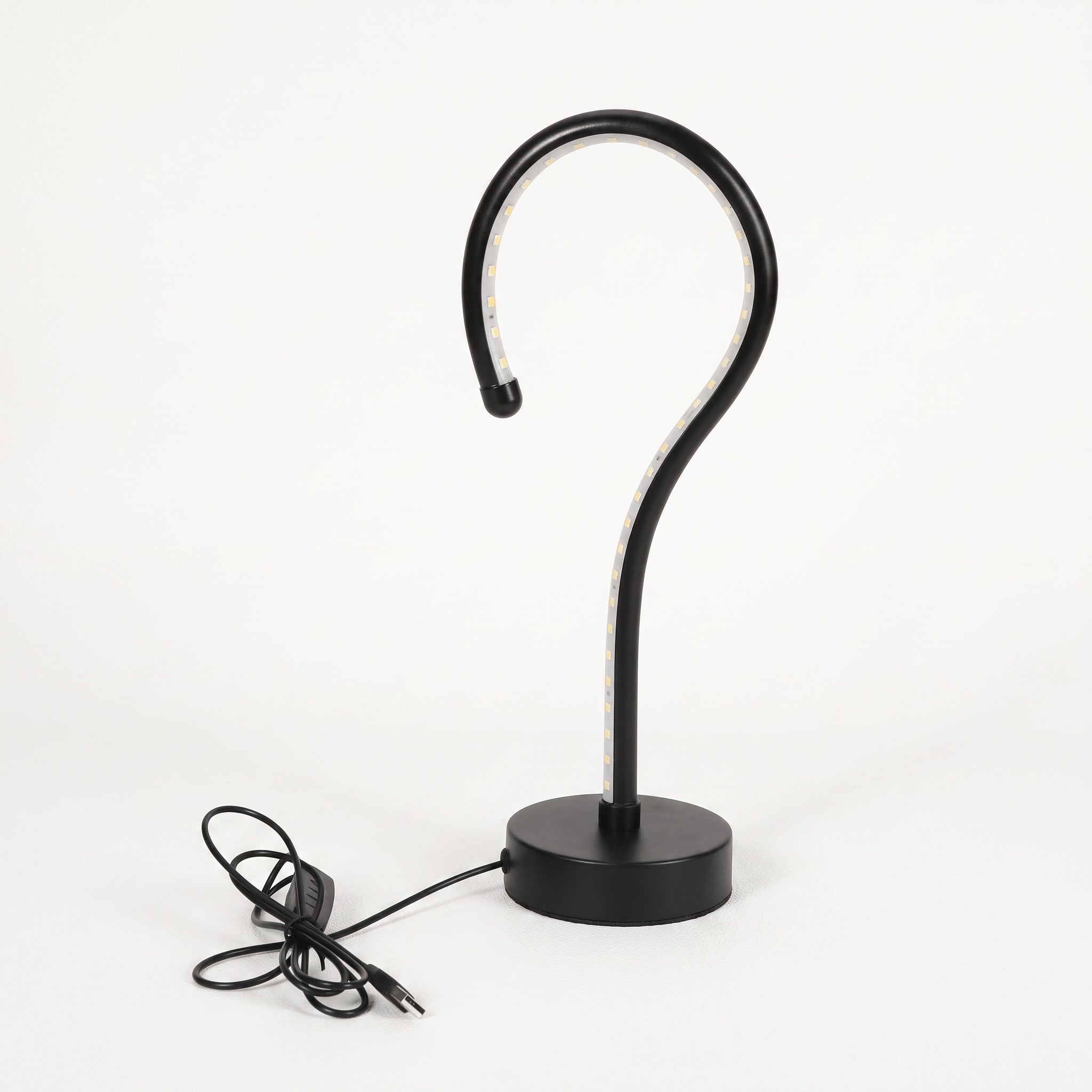 A modern black metal table lamp with a curved hook-shaped arm and a round base, shown with its power cord on a clean white background.