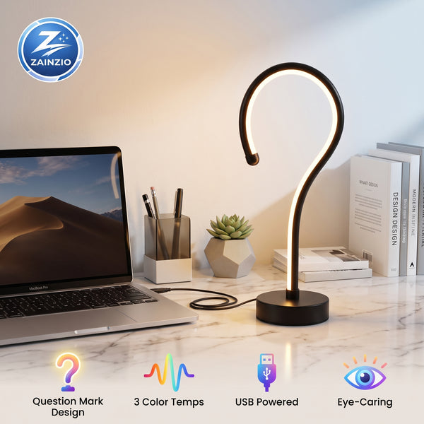 A curved black LED desk lamp with a glowing warm light sits on a white marble desk next to an open laptop, with a small succulent, pen holder, and books in the background. The image includes a ZAINZIO logo in the top-left corner and feature icons at the bottom.
