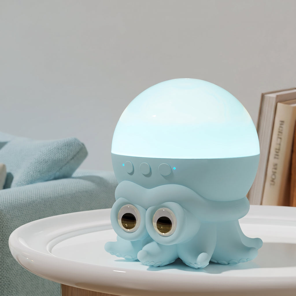 A cute light blue octopus-shaped night light with a glowing dome on top, sitting on a white table in a cozy room setting.