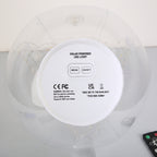Top-down view of a solar-powered LED light on an inflatable ring, showing the white circular control panel with mode and on/off buttons, CE and UKCA certification marks, and a small remote control in the corner.