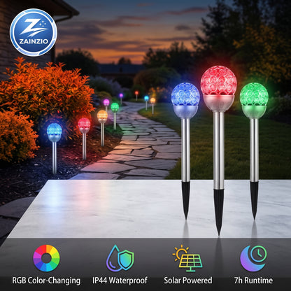 RGB solar garden path lights shown in a backyard garden pathway at dusk, with three lights illuminated in blue, red, and green on a metal stake. Features a ZAINZIO brand logo and feature icons at the bottom.