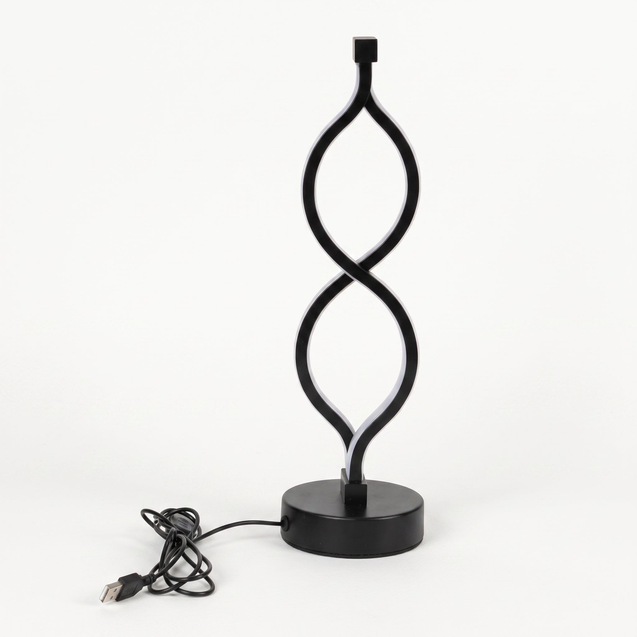 A modern black LED table lamp with a sculptural, twisting infinity-loop design on a round base, shown with its USB charging cable on a white background.