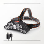 A black LED headlamp with multiple clear lenses and a black adjustable strap with orange stitching, shown on a white background with two small USB charging cables below it.