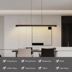 A modern linear LED pendant light with a dark wood-look frame hangs over a dining table in a minimalist interior. The image includes a dark gray banner at the bottom listing use cases such as Living Room, Dining Room, Restaurant, Hotel, Coffee Shop, Study Room, Office, and Cake Shop.