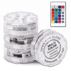 A stack of clear plastic underwater LED light cells with one open cell in front showing printed instructions, alongside a small remote control on a white background.